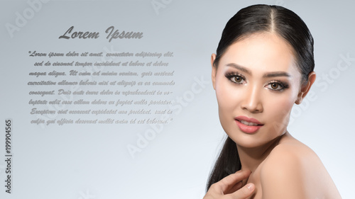 Beauty shot of young pretty asian woman with clear skin ongrey background, for skin ad and cosmetology with copy space for text insertion photo