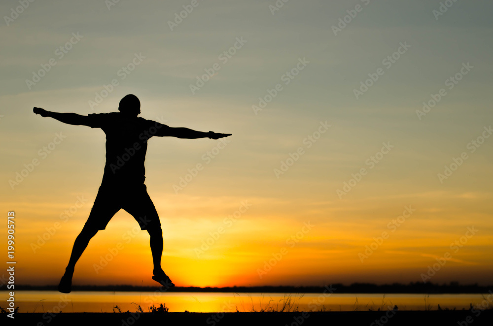 Men silhouette jumping happily.