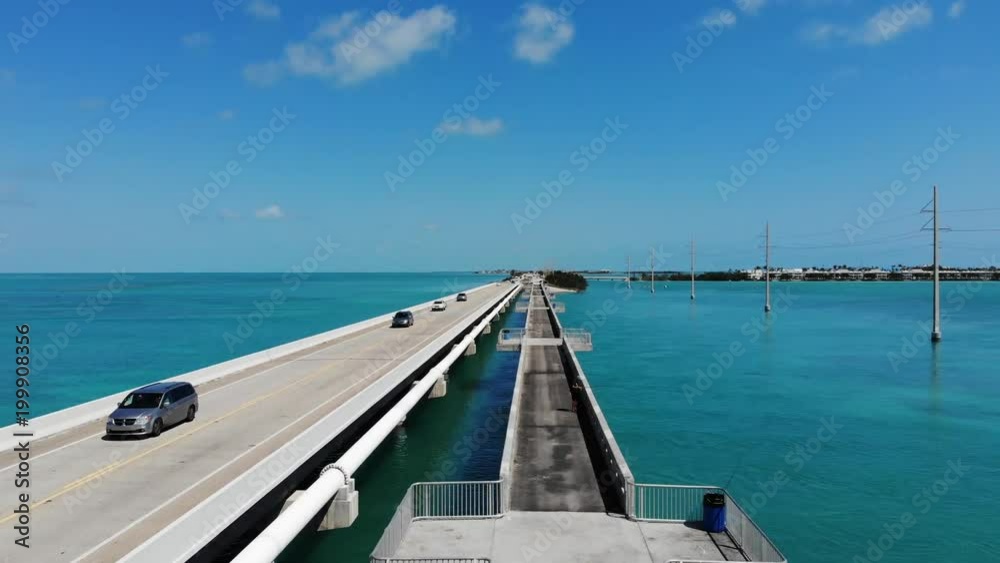 Aerial view of a highway and bridge connecting the Florida Keys. Fisherman and traffic on the bridge. Sunny day with warm blue water. Aerial view of a highway and bridge connecting the Florida Keys. Fisherman and traffic on the bridge. Sunny day with warm blue water.