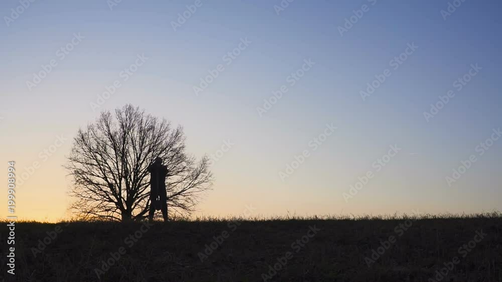 The silhouette of the workers shoveling the soil with a spade in the evening. The silhouette of the workers shoveling the soil with a spade in the evening.