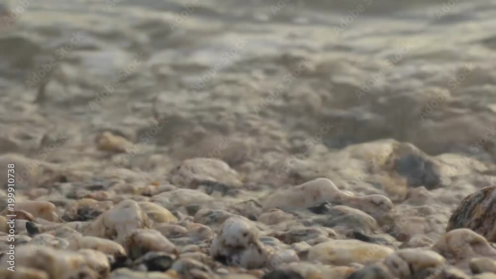 Waves calmly washing up rocky beach close up view Waves calmly washing up rocky beach close up view