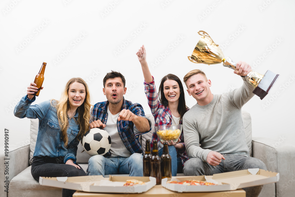 The four people on the sofa watch a football on the white background
