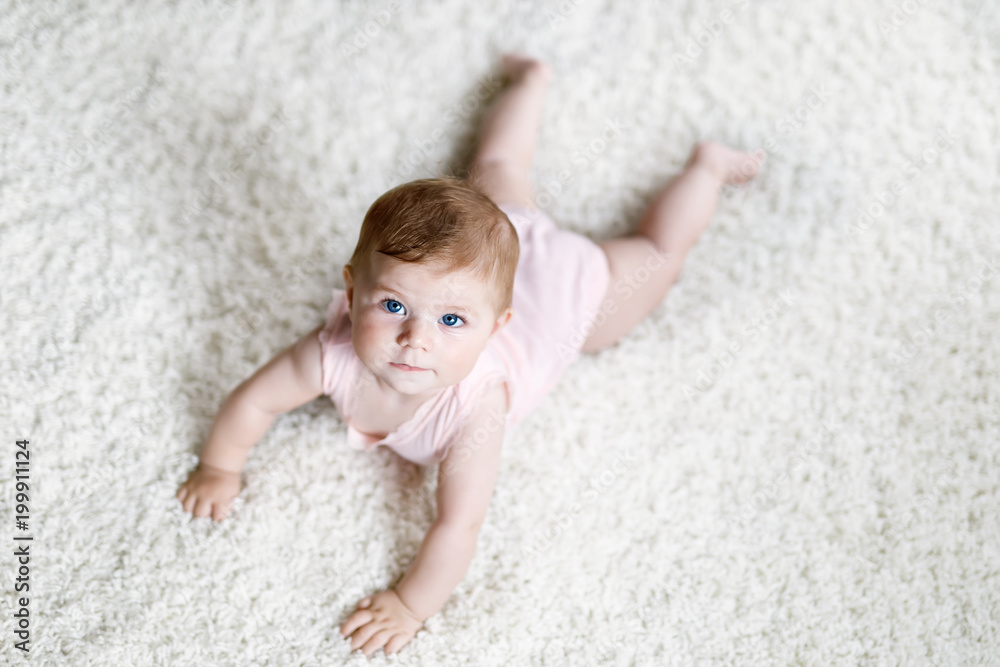 Little funny baby girl lifting body and learning to crawl. Little funny baby girl lifting body and learning to crawl.