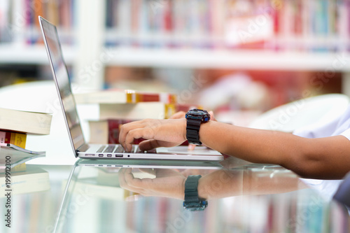 ose up student is searching for knowledge with laptop in the library.