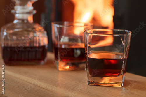 Glass of hard liquor in front of the fireplace.