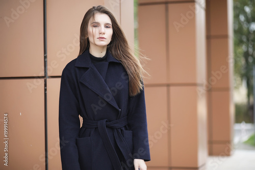 Beautiful girl in a coat in business downtown 