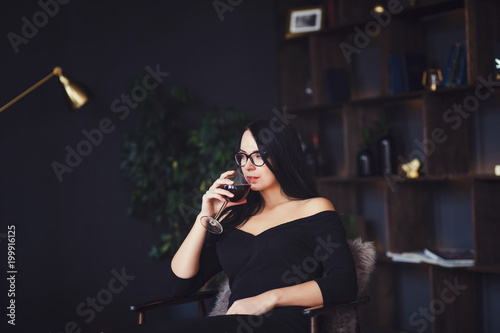 Portrait of young cheerful beautiful woman with glass of red wine