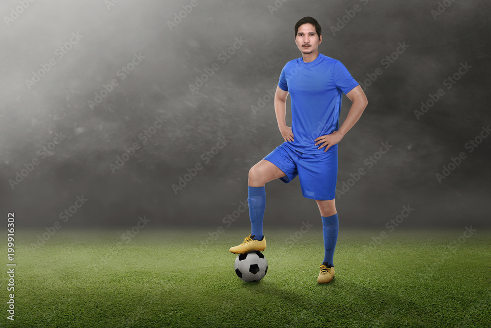 Young asian soccer player with hands on waist