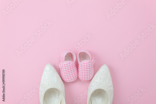 Top view aerial image of decoration Happy mothers day holiday background concept.Flat lay sign of season the pink rose with clothing woman & kid the couple shoes on pink paper at home office desk.