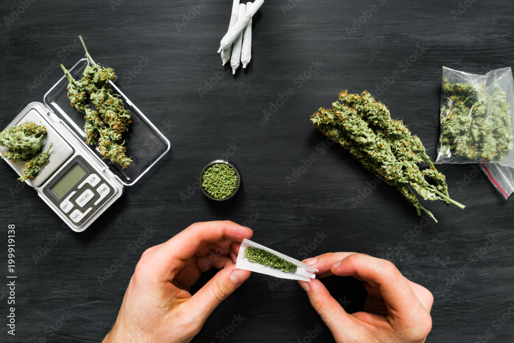 Φωτογραφία Not fully rolled jamb joint in the hands of a man marijuana weed The concept of