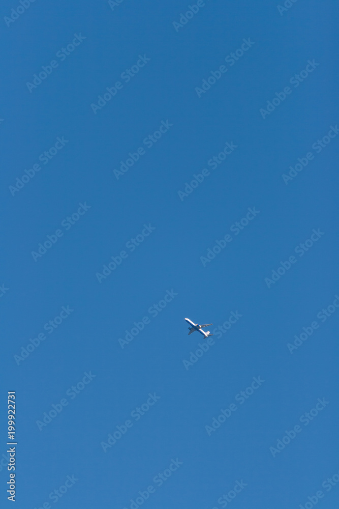 A passenger airplane in the cloudless spring April sky at sunset