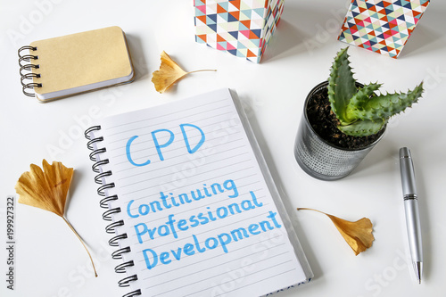 CPD Continuing Professional Development written in notebook on white table photo