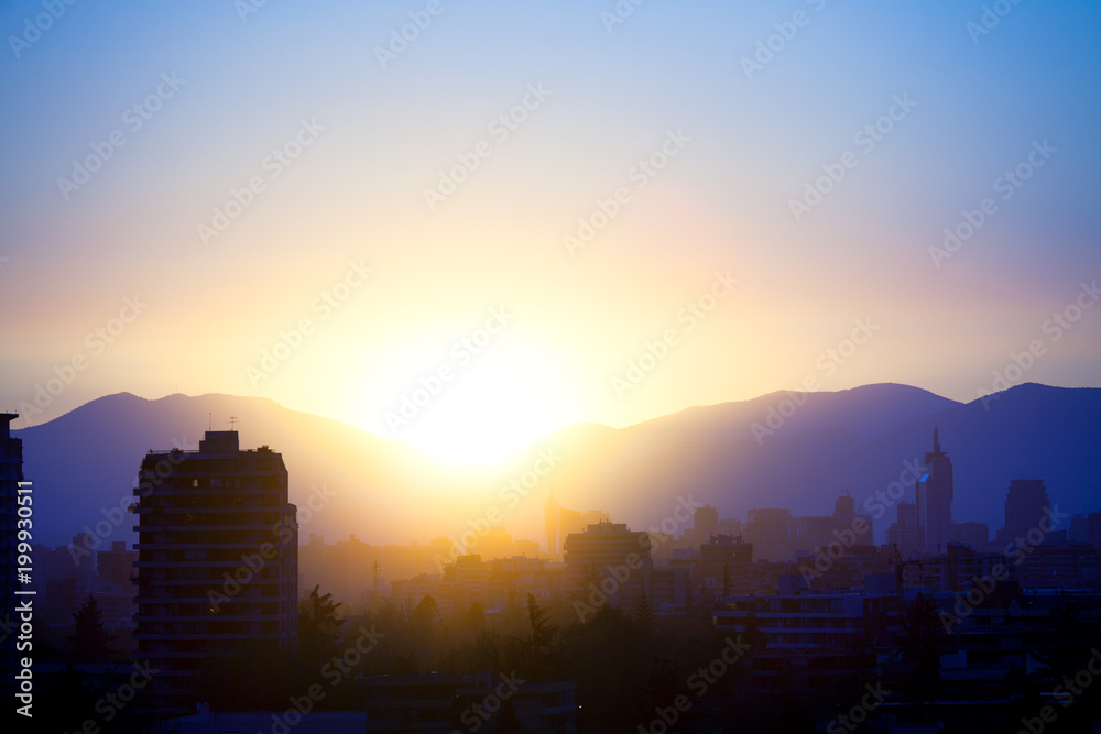 Skyline of downtown Santiago with buildings of Las Condes and Providencia districts against the setting sun, Chile, South America