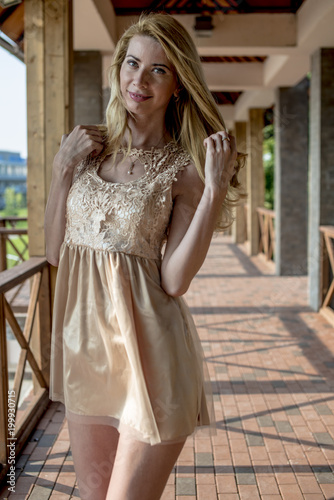 Young beautiful blonde woman in a beautiful dress on a Russian wooden staircase 