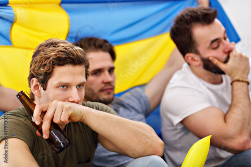 Happy male friends cheering and watching sports on tv photo