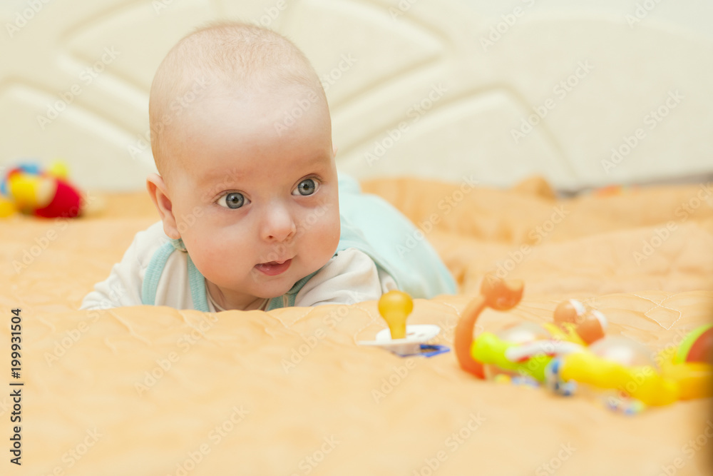 the baby lies on his tummy and watches the toys the baby lies on his tummy and watches the toys