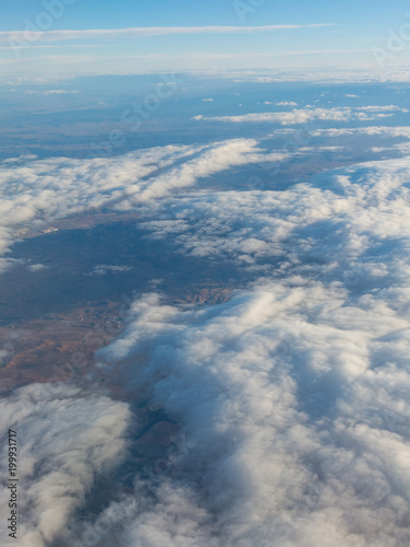 Aerial view of the Madrid region, outside the metropolitan area. Flying over agricultural fields and clouds.
