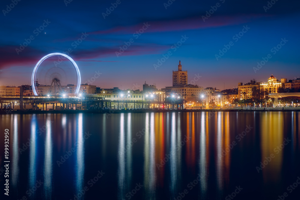 View of Malaga city and Ferris wheel from harbour, Malaga, Spain