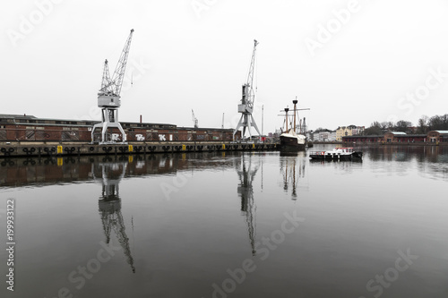 Lubeck, Germany. Boat and cranes at the harbor in the river Trave in Lubeck