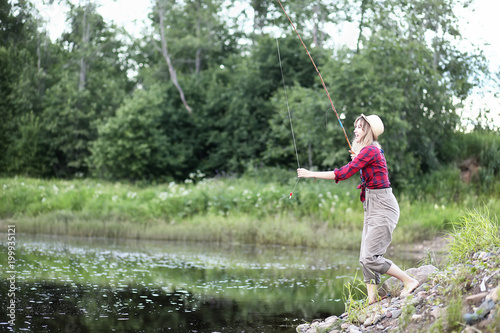 Girl by the river with a fishing rod