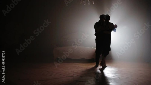 Couple dancing tango in the fog photo