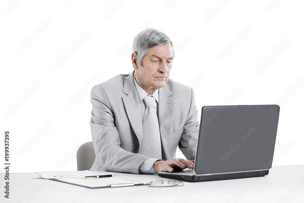 senior businessman working on laptop while sitting at his Desk senior businessman working on laptop while sitting at his Desk