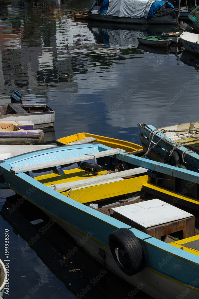 photograph of wooden fishing boats parked together on urca beach in the city of rio de janeiro