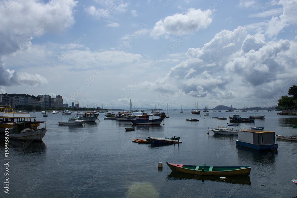 Fototapeta premium boats and fishing boats parked together on urca beach in rio de janeiro city on sunny day with clouds