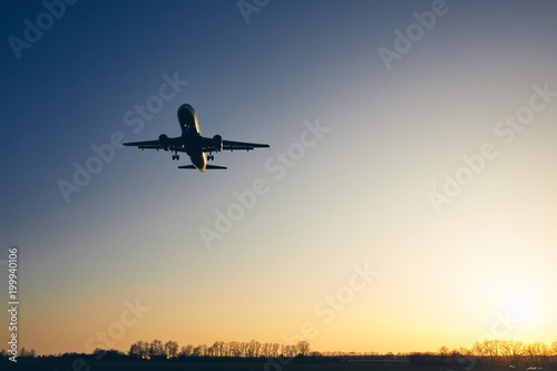 Airplane landing at golden sunset