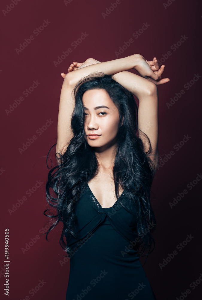 Beautiful asian woman in black dress posing in studio Beautiful asian woman in black dress posing in studio