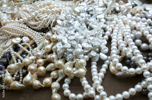 Heap of various pearl necklaces as background