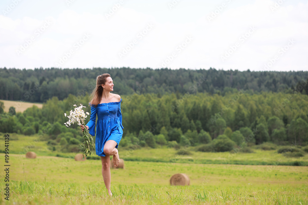 Young cute girl run in a field at sunset