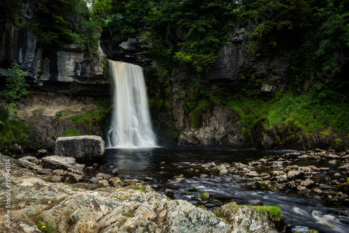Water cascades over rocks into a pool. Thornton force on the Ingleton waterfalls trail, Yorkshire, England, uk.