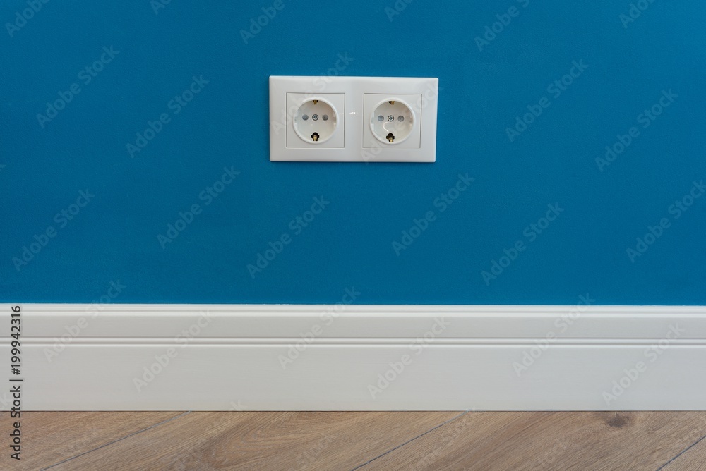 European standard 220 volt wall electrical outlet on wall with baseboard and hardwood floor European standard 220 volt wall electrical outlet on wall with baseboard and hardwood floor