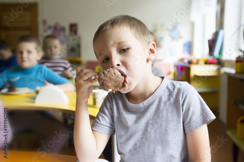Eating in the kindergarten. Nutrition of the preschooler. The child eats a cutlet ..