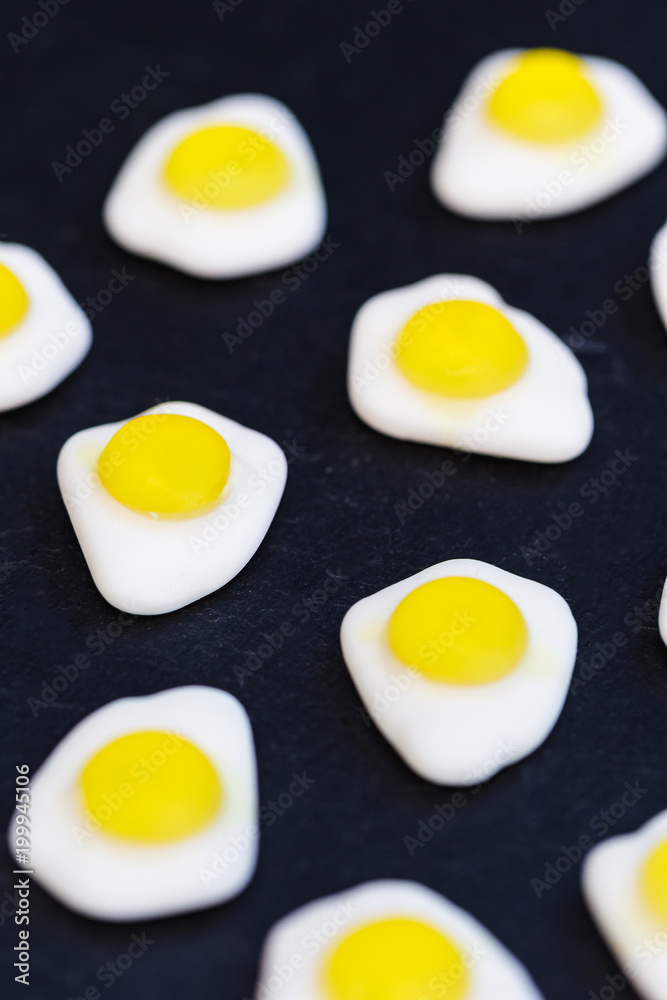 Fried eggs candy sweets on dark background