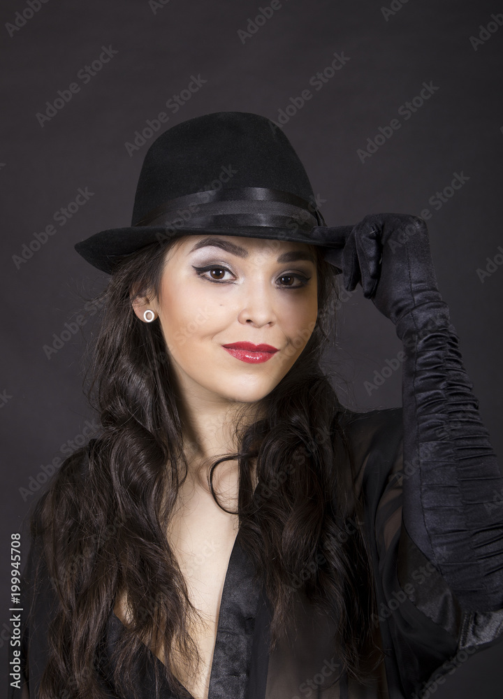 Beautiful young girl in black tunic, black gloves and black hat. Beautiful young girl in black tunic, black gloves and black hat.