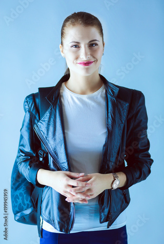 portrait of beautiful young brunette woman in stylish black jacket on gray. photo