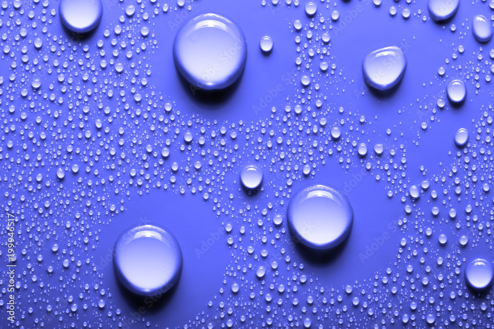 Small and large drops of water on a colored background. Abstract liquid sprays