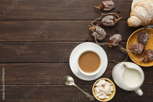 Coffee cup and sweets on vintage wooden table, top view