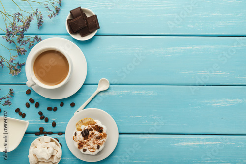 Coffee cup and sweets on blue vintage wooden table, top view