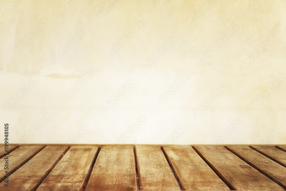 Brown wooden plank table against bright yellow wall blurred in background. Bright summer mock up, empty product display. Text space