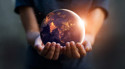 Earth at night was holding in human hands. Earth day. Energy saving concept