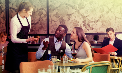 Couple talking with waitress in restaurant