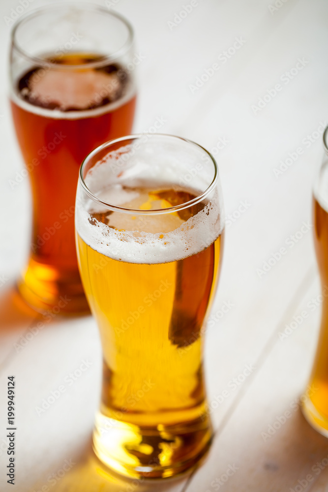 glasses of assorted beer with wheat on a wooden table background for tasting