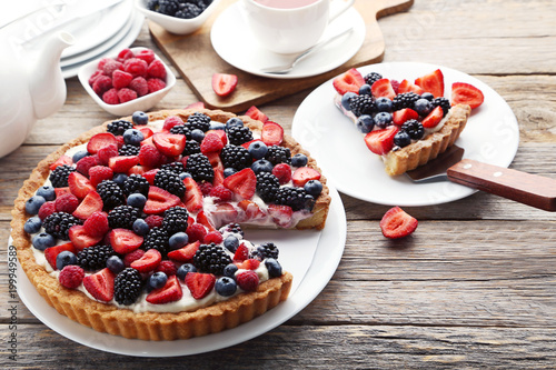 Fototapeta Sweet tart with berries on grey wooden table