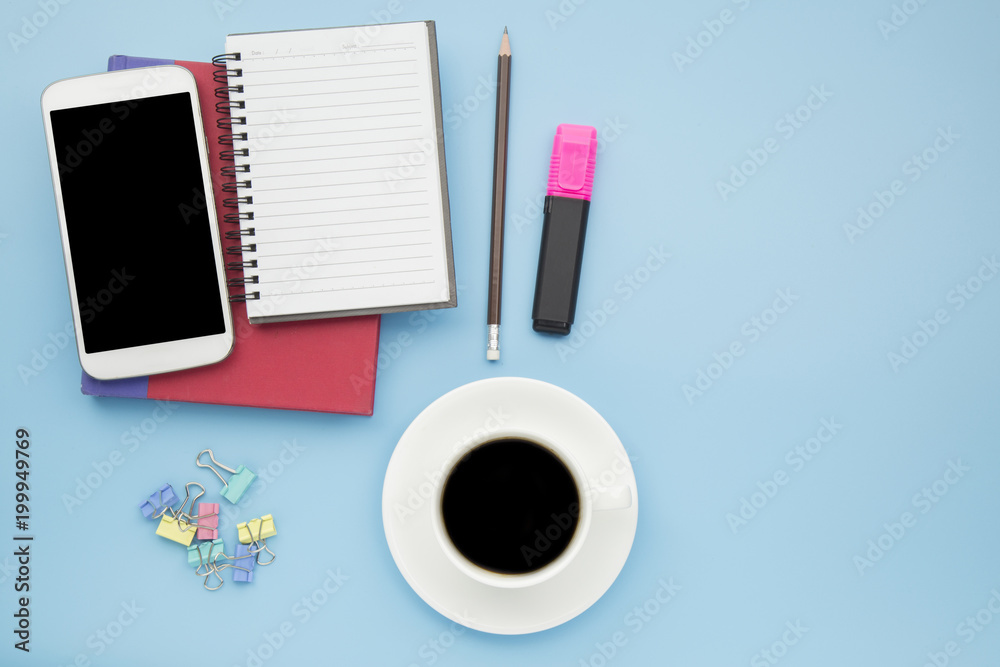 Notebook red cover mobile phone and black coffee white cup on blue background pastel style with copyspace flatlay clipping path at screen. Notebook red cover mobile phone and black coffee white cup on blue background pastel style with copyspace flatlay clipping path at screen.