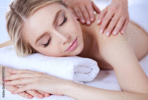 Young woman lying on a massage table,relaxing with eyes closed. Woman. Spa salon