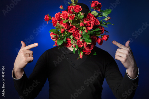 Fototapeta Naklejka Na Ścianę i Meble -  Man with a bouquet of flowers. Man with a bouquet of roses. Congratulations on the holiday. Festive decoration with flowers.