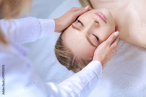 Young woman lying on a massage table,relaxing with eyes closed. Woman. Spa salon